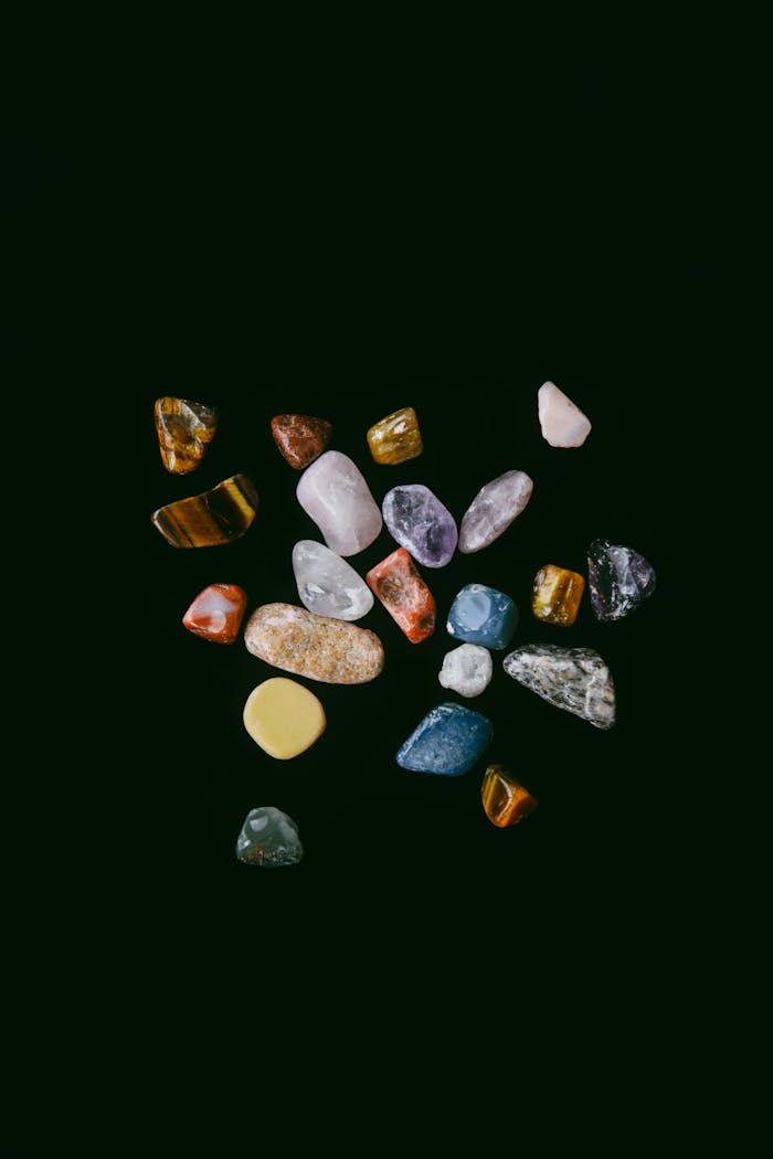brand-01 A diverse collection of colorful minerals and gemstones on a dark studio backdrop.