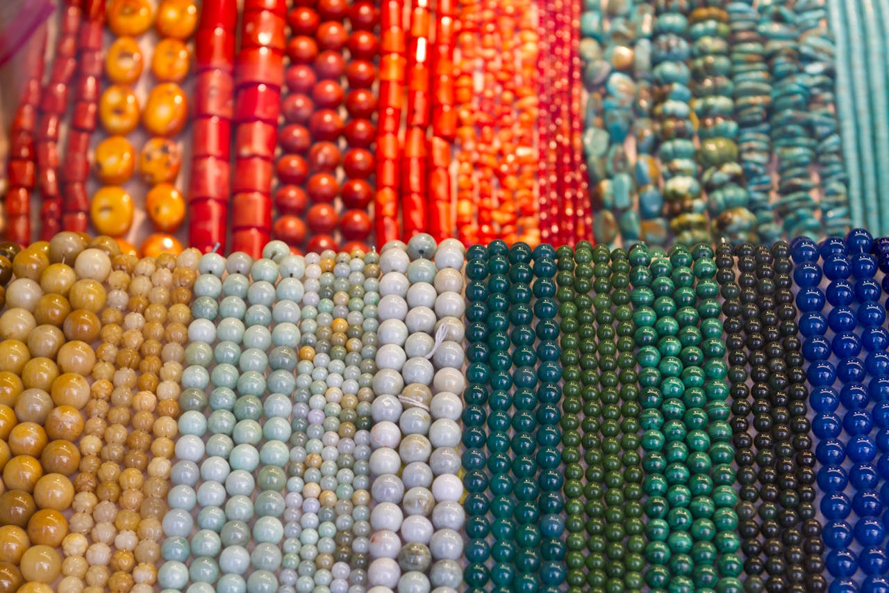 digital Vibrant and diverse collection of gemstone bead strands in various colors and sizes on display.