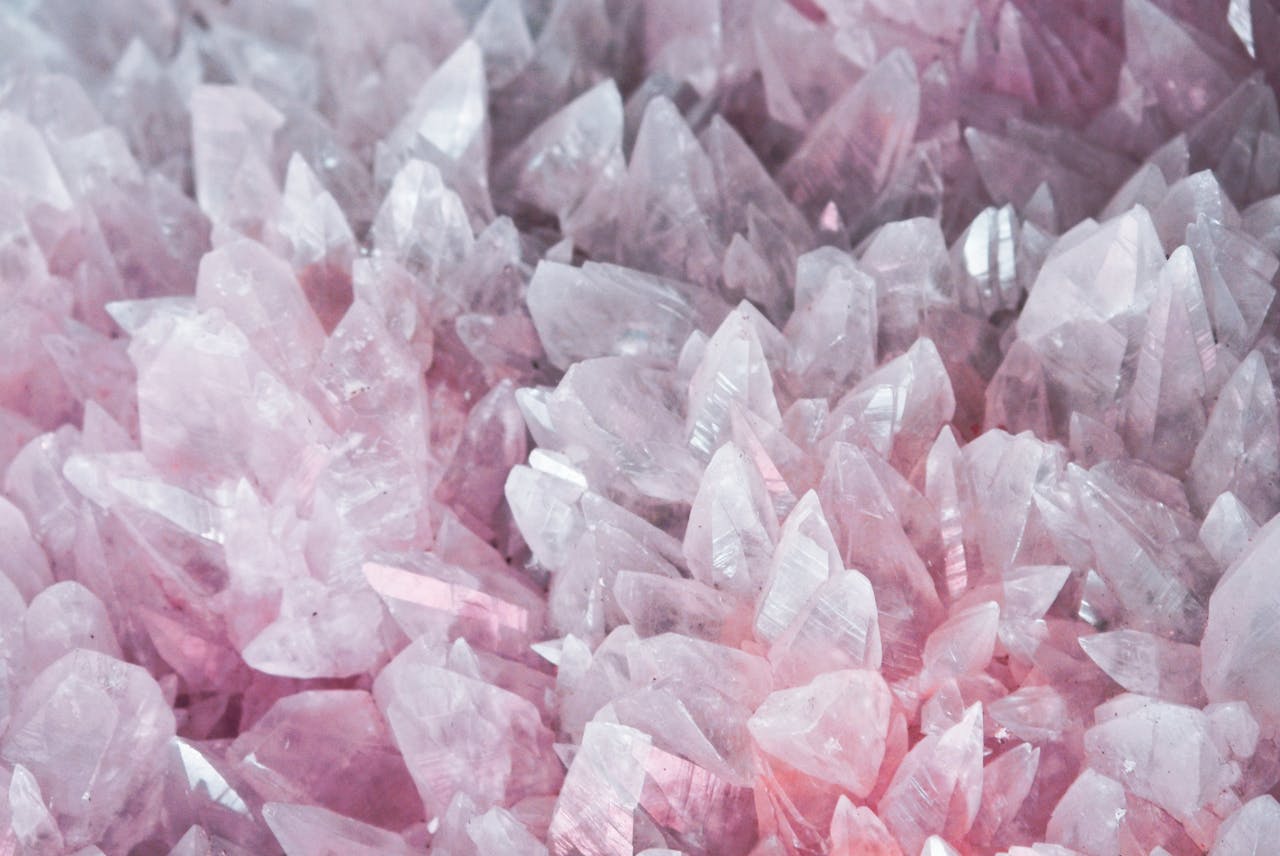 Services-03 A detailed close-up of rose quartz crystals showcasing their pink hues and translucent nature.