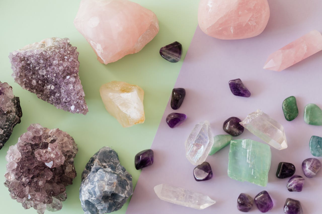Services-01 A variety of crystals and gemstones including amethyst and rose quartz on a pastel background.