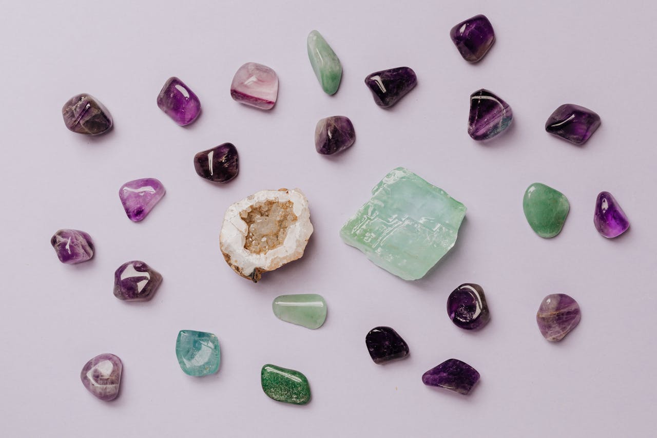 Services-02 Flat lay of assorted polished gemstones including amethyst and jade on a light background.
